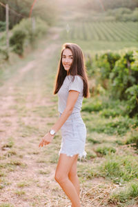 Portrait of smiling young woman standing on field