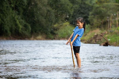 Smiling girl standing in river