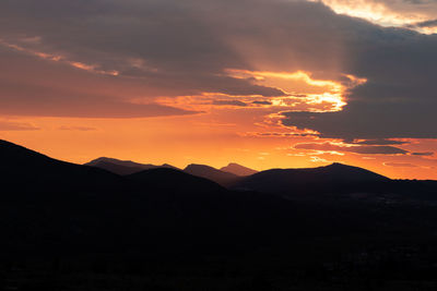 Scenic view of silhouette mountains against sky during sunset