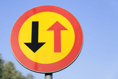 Close-up of road sign against clear blue sky