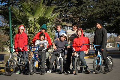 Group of people sitting on road against trees