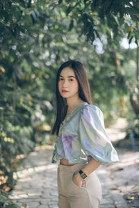 Portrait of beautiful young woman standing in park