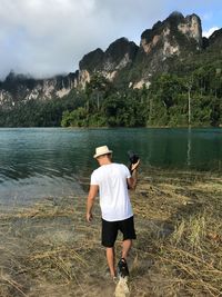 Rear view of man in lake against mountains