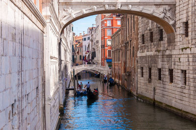 People in canal along buildings