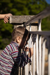 Rear view of woman standing by fence