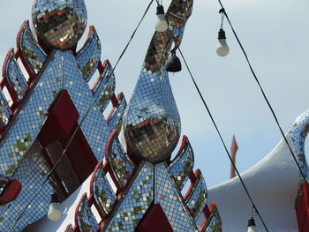 Low angle view of people hanging against sky