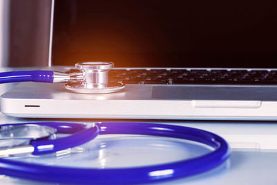 Close-up of laptop with stethoscope on table