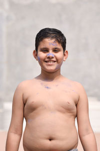 Portrait of smiling shirtless boy standing