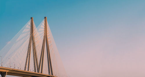 Low angle view of bridge over building against clear sky