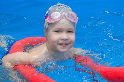 Boy in swimming goggles and a swimming cap in the pool