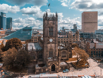 Buildings in city against cloudy sky