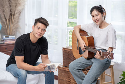 Young couple sitting on guitar