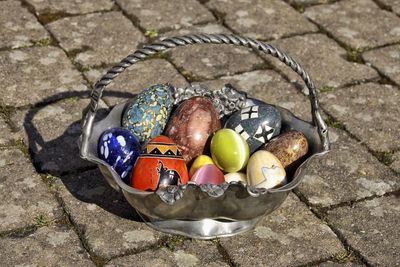 High angle view of easter eggs in metallic basket on footpath