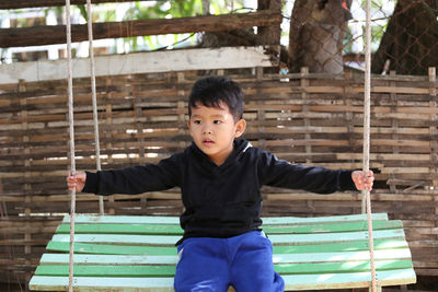 Cute boy sitting on swing