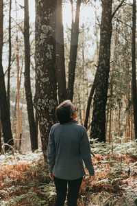 Rear view of woman walking in forest