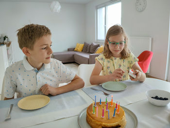 Smiling sibling celebrating birthday at home