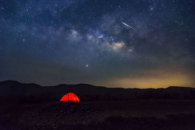 Red tent in reservoir under milky way galaxy with stars. baan sop pat, mae moh lampang thailand.