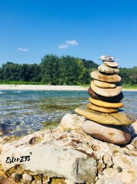 Stack of stones on rock against sky