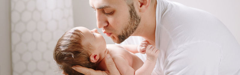 Close-up of father holding baby at home
