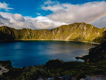 Scenic view of lake by mountains against sky