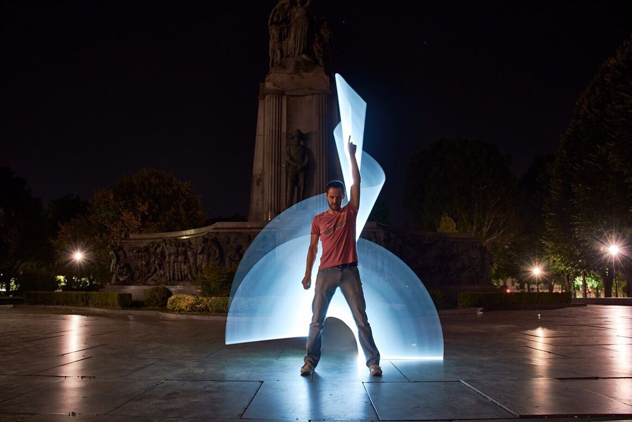 BOY IN ILLUMINATED PARK AT NIGHT