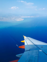 Airplane flying over sea against blue sky