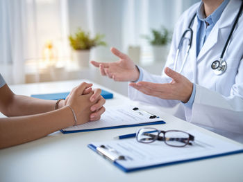 Midsection of doctor examining patient at clinic