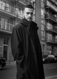 Portrait of man standing on street in city