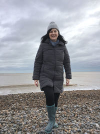 Full length of man standing on beach against sky