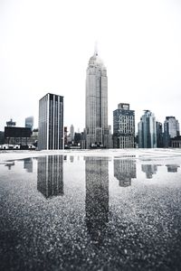 Sea and cityscape against clear sky