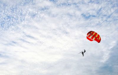 Low angle view of paragliding against sky