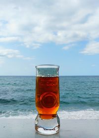 Wine glass on beach against sky