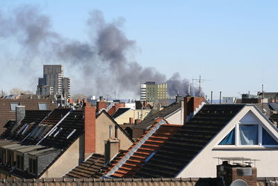 Smoke over city against sky