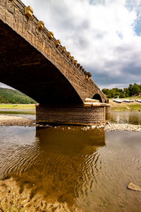 View of bridge over river against cloudy sky