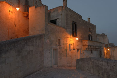 Street amidst buildings against sky at night