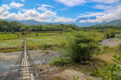 Scenic view of railroad tracks on field against sky