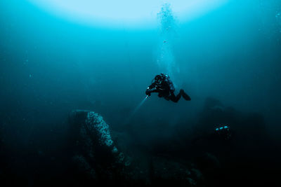 Woman with flashlight swimming in sea