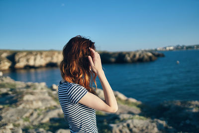 Beautiful woman standing in water against sky