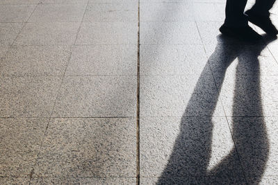 Low section of person standing on footpath