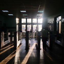 Rear view of people walking in illuminated corridor