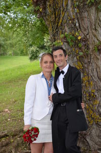 Happy couple standing against plants