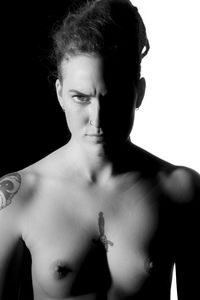 Portrait of shirtless man against black background