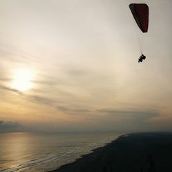 Low angle view of two people parachuting in sky