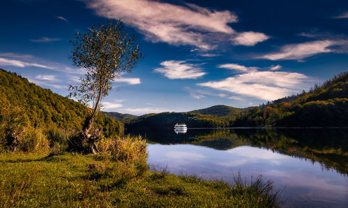 Passenger boat on calm water of urftsee in eifel national park in germany in autumn.