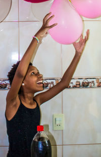 Portrait of young woman with balloons at home