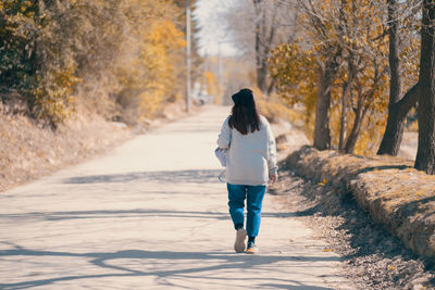 Woman walking on a footpath surrounded by nature