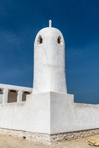 Low angle view of a minaret against a clear blue sky