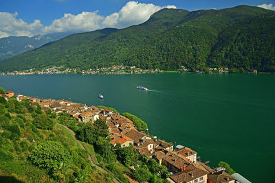 Scenic view of sea by mountain against sky