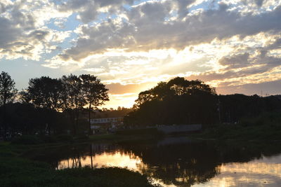 Reflection of trees in lake during sunset