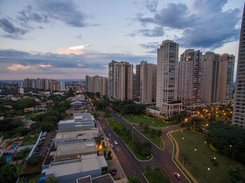 High angle view of illuminated street amidst buildings in city against sky